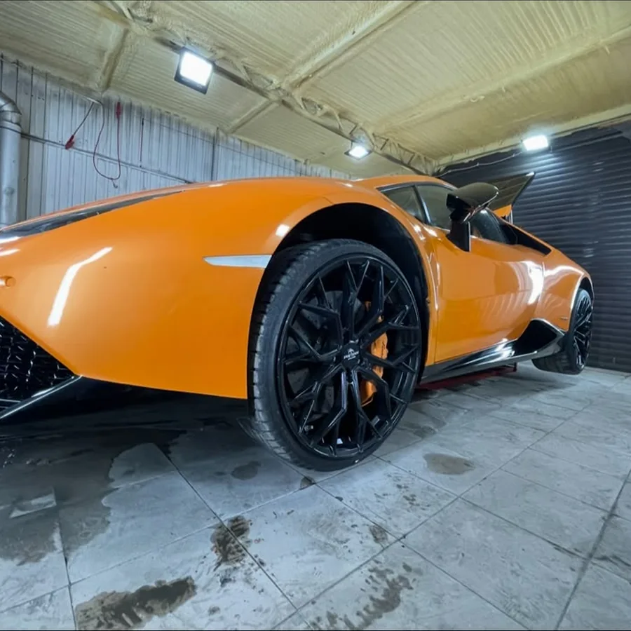 Pomarańczowe auto sportowe w studiu detailingowym