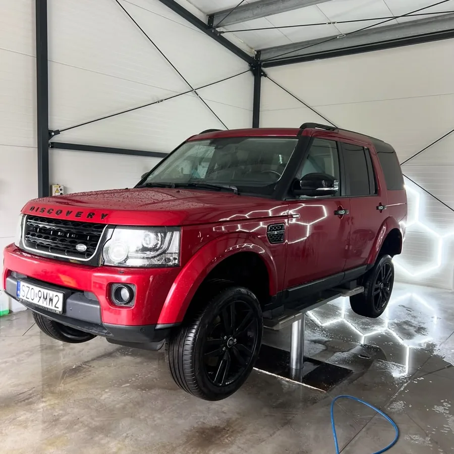 Czerwony SUV na stanowisku detailingowym